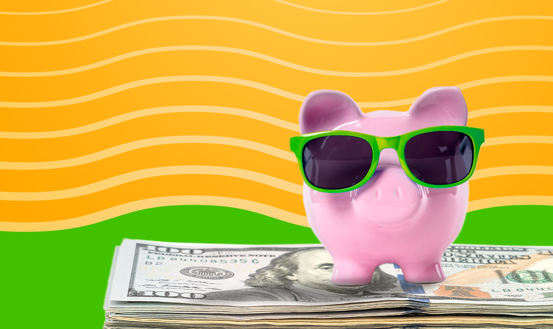 piggy bank wearing sunglasses sits atop a stack of U.S. currency